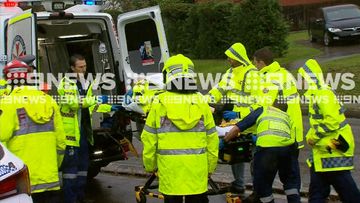 Emergency services load the injured police officer into an ambulance.