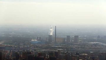 White smoke billows from a coal-fired power plant near the residential buildings in Beijing, Saturday, Sept. 3, 2016. China announced on Saturday that it has ratified the emissions-cutting agreement reached last year in Paris, giving a big boost to efforts to bring the accord into effect by the end of this year. (AAP)