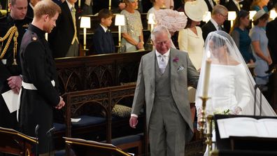 Britain's Prince Harry looks at his bride, Meghan Markle, as she arrives accompanied by the Prince Charles during the wedding ceremony of Prince Harry and Meghan Markle at St. George's Chapel in Windsor Castle in Windsor, near London, England, Saturday, May 19, 2018