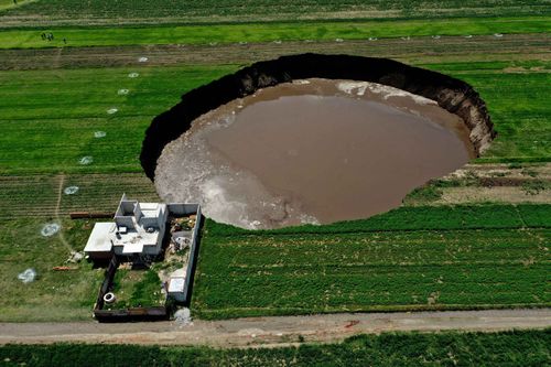 Aerial view of a sinkhole that was found by farmers in a field of crops in Santa Maria Zacatepec, state of Puebla, Mexico.