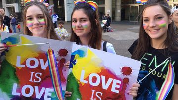 Same-Sex marriage activists Megan Robinson,16, Demi Foundas, 15, Emma Langan, 15, march during today’s rally  in support of same-sex marriage in Sydney. (AAP)