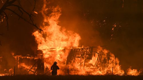 NSW Rural Fire Service crews fight the Gospers Mountain Fire as it impacts a structure at Bilpin.