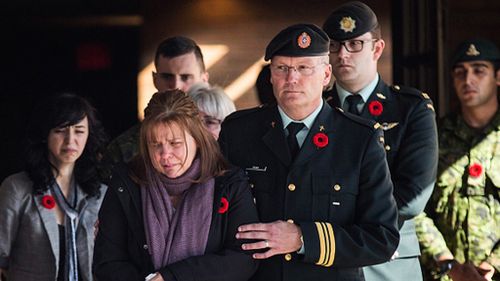 Cirillo's mother supported by military personnel.