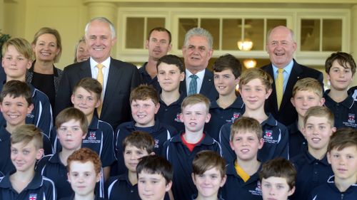 Australian Prime Minister Malcolm Turnbull (left) and Newly sworn-in Assistant Health Minister Ken Wyatt pose for photographs with school kids from Gullford Grammar School during a ceremony at Government House in Canberra in September, 2015. (AAP)