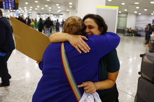 LONDON, ENGLAND - OCTOBER 13: A member of London's Israeli community (L) hugs an Australian citizen evacuated from Israel, at Terminal 3, Heathrow on October 13, 2023 in London, England. 238 Australian nationals are on the flight  to London Heathrow following the Hamas surprise attack on Israel last Saturday left 1300 dead and as many as 150 people were taken hostage and moved to Gaza.  (Photo by Peter Nicholls/Getty Images)