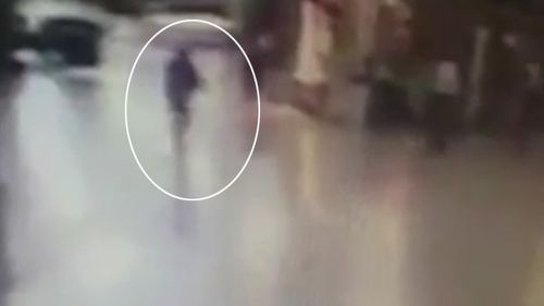 The terrorist is seen running through the terminal holding an AK-47