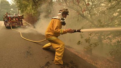 Eagle Field Fire Department firefighter Mark Jones extinguishes hot spots during the Glass Fire in St. Helena, California.