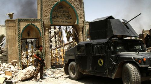 An Iraqi soldier stands next to the destroyed Great Mosque of al-Nuri in the old city area western Mosul, Iraq, in July 2017. (AAP)