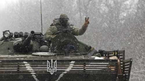 A Ukrainian soldier in a tank displays the peace sign. (AAP)