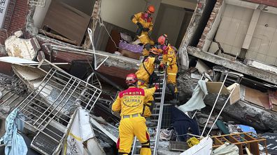 Members of a search and rescue team prepare to enter a leaning building following an earthquake in Hualien, eastern Taiwan on Wednesday, April 3, 2024.  