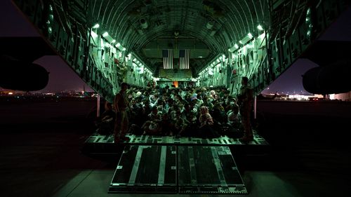 Evacuees board a US military C-17 Globemaster III aircraft at Hamid Karzai International Airport 