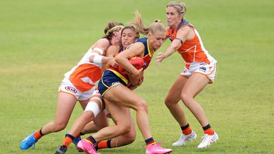 Ashleigh Woodland of the Crows is tackled by Rebecca Beeson of the Giants during the AFLW pre-season.