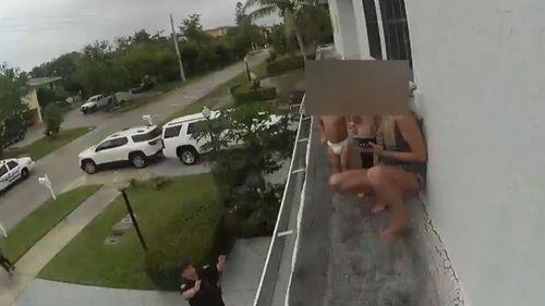 The woman and two toddlers were found on a narrow building ledge about six-metres high. (Delray Beach Police) 