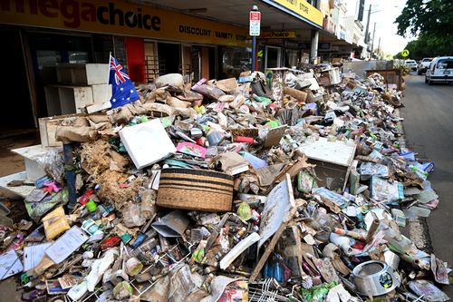 Piles of flood-damaged goods line a main street in central Lismore as residents are returning to their properties to survey the damage. 