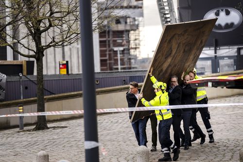 CEO of Danish Business, Brian Mikkelsen, and others carry paintings out of the burning building as the Stock Exchange burns in Copenhagen, Denmark, Tuesday, April 16, 2024. 
