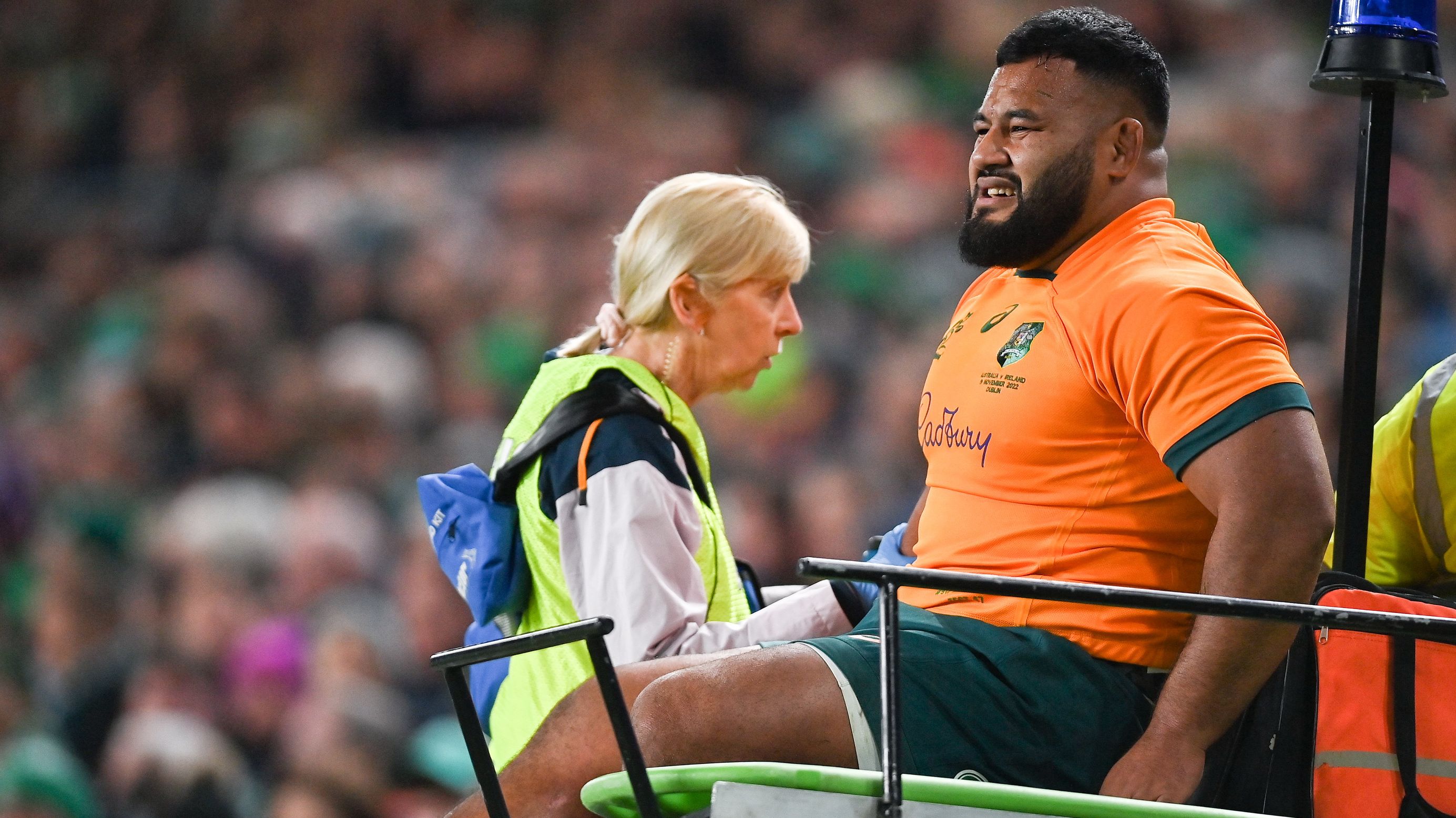 Taniela Tupou of Australia is taken from the pitch to receive medial attention.