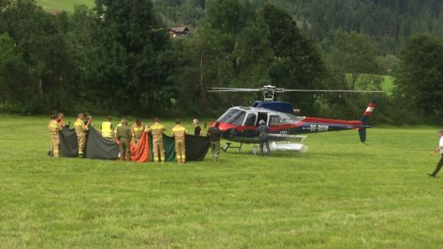 Rescuers stand next to a police helicopter in Krimml in the Austrian province of Salzburg. (AP)