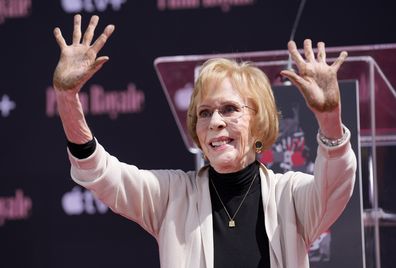 Comedian Carol Burnett holds up her hands after putting them in cement during a ceremony for her at the TCL Chinese Theatre, Thursday, June 20, 2024, in Los Angeles. (AP Photo/Chris Pizzello)