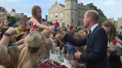Prince William receives a gift from a young fan. 