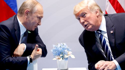Vladimir Putin whispers to Donald Trump as the pair prepare to discuss 'very positive things'. (AAP)