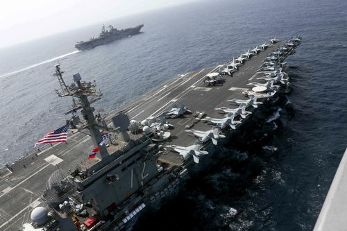 In this Friday, May 17, 2019, photo released by the U.S. Navy, the USS Abraham Lincoln sails in the Arabian Sea near the amphibious assault ship USS Kearsarge. Commercial airliners flying over the Persian Gulf risk being targeted by "miscalculation or misidentification" from the Iranian military amid heightened tensions between the Islamic Republic and the U.S., American diplomats warned Saturday, May 19, 2019, even as both Washington and Tehran say they don't seek war. (Mass Communication Speci