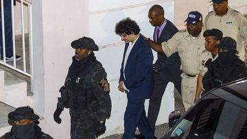 Samuel Bankman-Fried, center, is escorted out of the Magistrate Court building the day after his arrest in Nassau, Bahamas, Tuesday, Dec. 13, 2022. 