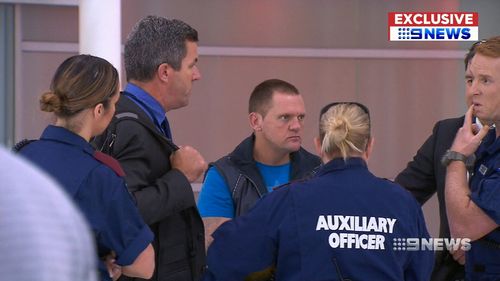 Robert Troy Scanlon, 45, was met by armed officers today as he touched down in Perth after being extradited from Brisbane today.

