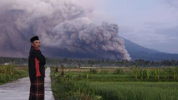 A man looks on as Mount Semeru releases volcanic materials during an eruption on Sunday, in Lumajang, East java, Indonesia.