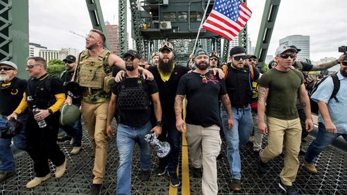 Members of the Proud Boys and other right-wing demonstrators march across the Hawthorne Bridge during a rally in Portland, Oregon.