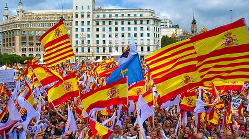 Thousands of people waving Catalan and Spanish flags gathered in central Barcelona to call for national unity. (Photo: AAP).
