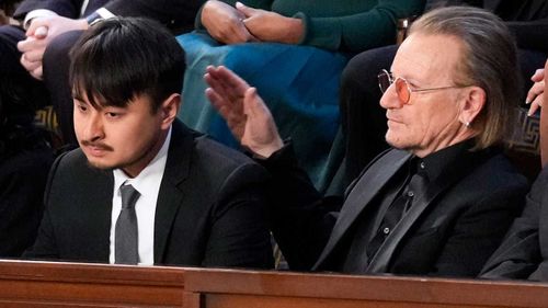 Brandon Tsay, who wrestled a gun from a mass shooter, gets a pat on the back from U2 singer Bono.