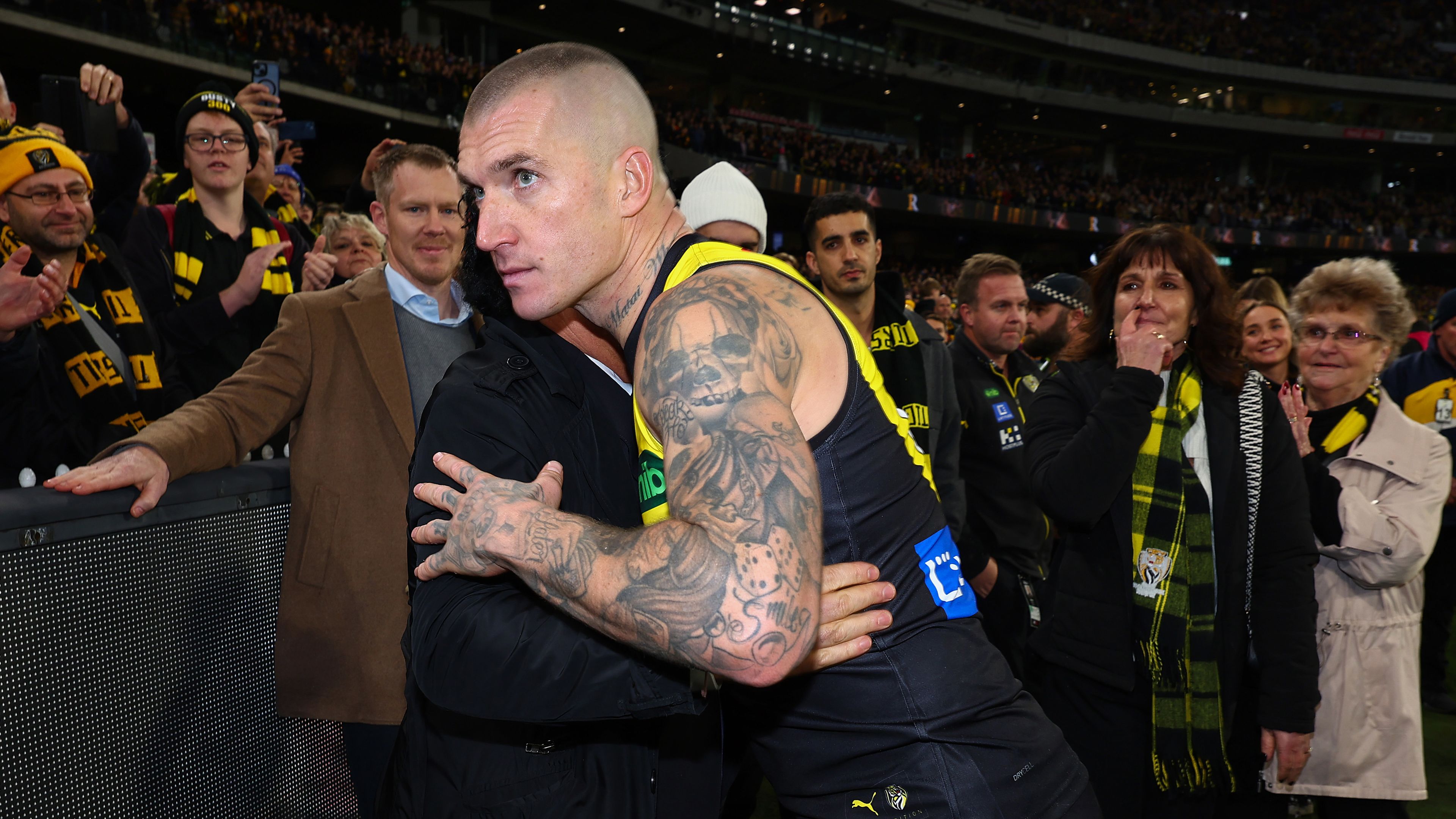Dustin Martin of the Tigers embraces his agent Ralph Carr following his 300th match.