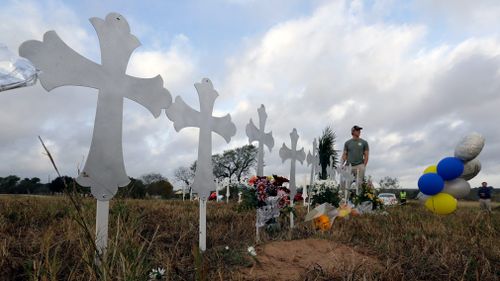 Kyle Dahlberg visits a makeshift memorial for victims near the scene of the shooting. (AAP)