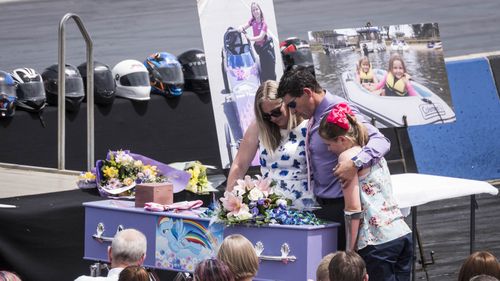 Anita Board's mother Sonja (centre), father Ian (second right) and sister Zara embrace at the funeral. (AAP) 