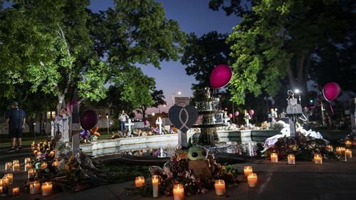 Candles are lit at dawn at a memorial site in the town square for the victims killed in this week's Robb Elementary School shooting Friday, May 27, 2022, in Uvalde, Texas.