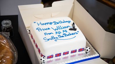 Prince William, Duke of Cambridge is presented with a birthday cake by shop owner Paul Brandon during a visit to Smiths the Bakers, in the High Street on June 19, 2020 in King's Lynn, Norfolk.