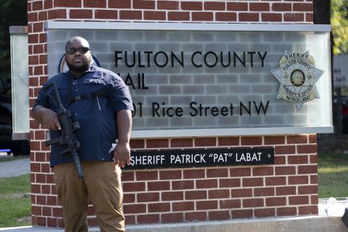 An official stands guard in front of the Fulton County Jail in Atlanta on Thursday, Aug. 24, 2023. 