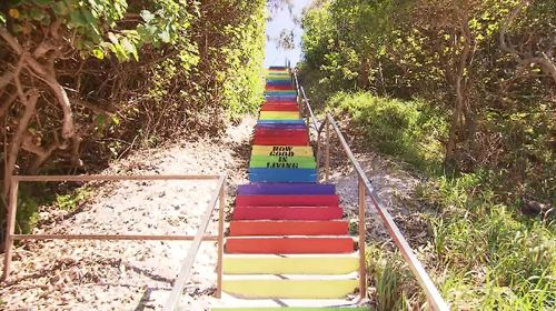 This colourful staircase has become the centre of a war of words in a Queensland beach town.
