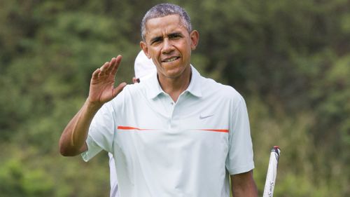 Mr Obama waves to travelling press during his round. (AAP)
