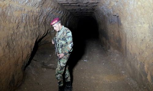 A Syrian soldier stands at one of the underground tunnels under the recently-captured Jobar town in the Eastern Ghouta, in the countryside of Damascus, Syria. (AAP)