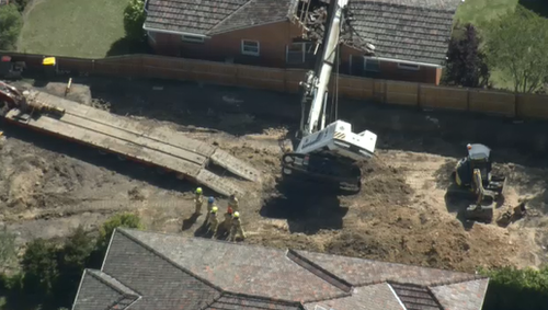 A drill rig has fallen onto a home in Strathmore.