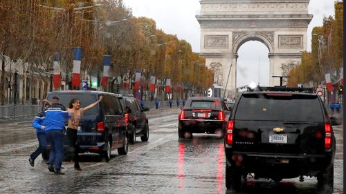 Topless protester runs at Donald Trump's motorcade on Champs Elysees