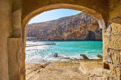 The view of the Dwejra Inland Sea and the Blue Hole Cave through the arch of the old boathouse in the fishing village of San Lawrenz, Gozo Island, Malta.