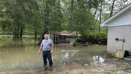 Miguel Flores Sr. stands in his flooded backyard outside his home in the northeast Houston neighborhood of Kingwood on Saturday, May 4, 2024. Officials said the area had about four months of rain in about a weeks time. (AP Photo/Juan Lozano)