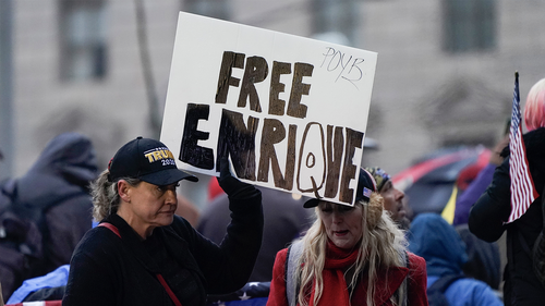 People hold a sign reading 'Free Enrique' in reference to Proud Boys leader Henry "Enrique" Tarrio, who was arrested on Monday when he arrived back in the District, as they attend a rally at Freedom Plaza Tuesday, Jan. 5, 2021, in Washington, in support of President Donald Trump. Tarrio was arrested and accused of burning a Black Lives Matter banner that was torn down from a historic Black church in downtown Washington last month. 