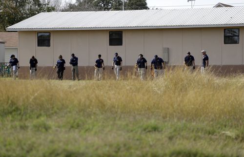 Law enforcement officials investigate the scene of the shooting. (AAP)