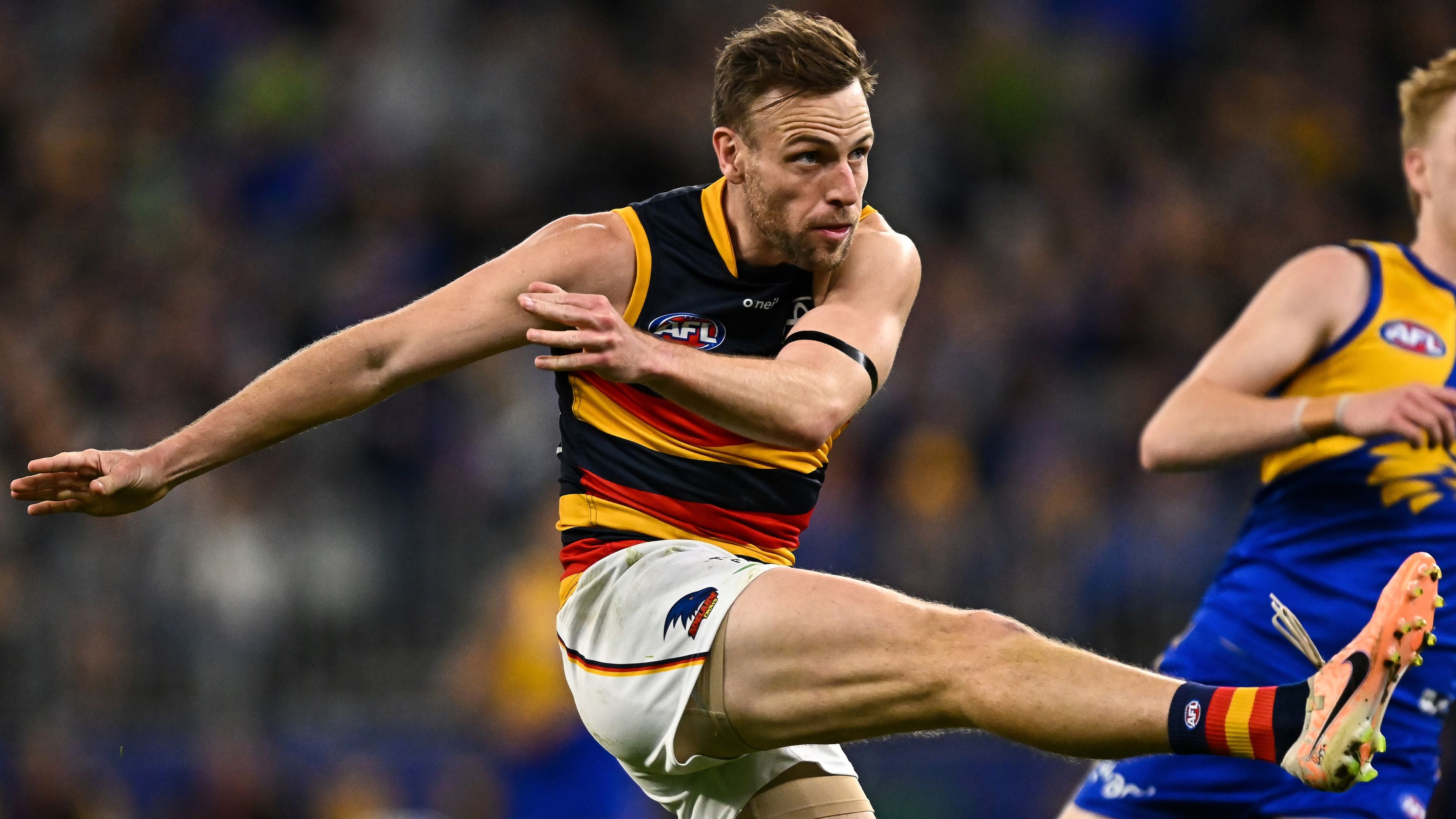 Brodie Smith of the Crows kicks the ball.