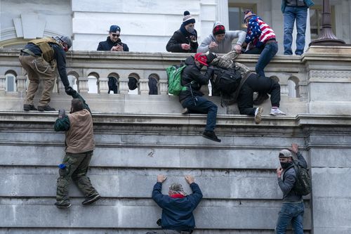 Rioters loyal to President Donald Trump climb the west wall of the the U.S. Capitol, Jan. 6, 2021, in Washington. 