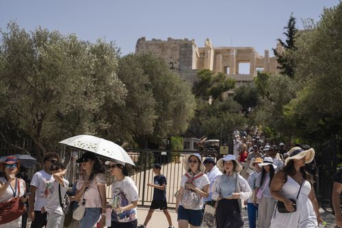 Tourists exit the ancient Acropolis of Athens as the Greek culture ministry shut down the monument most of the day because of heat, Friday, July 14, 2023.