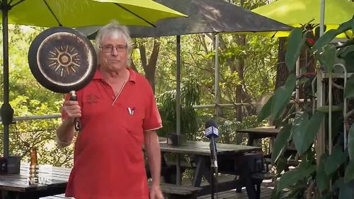 A brave Darwin pub owner has found a peculiar but effective way to fend off a huge saltwater crocodile.